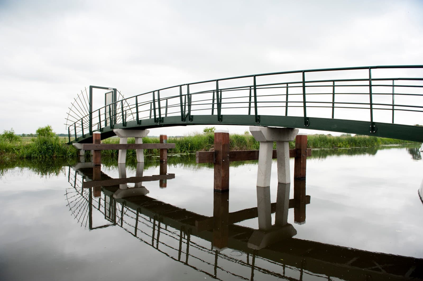 De fietsbrug met weerspiegeling in het water